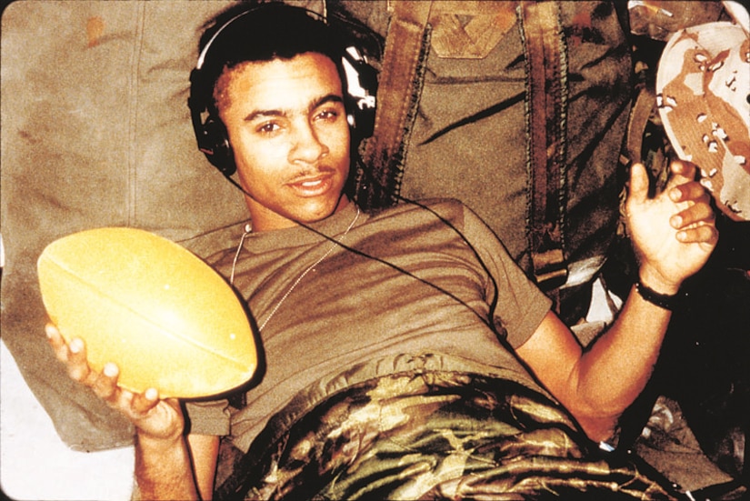 A Marine relaxes on bed with headphones on.